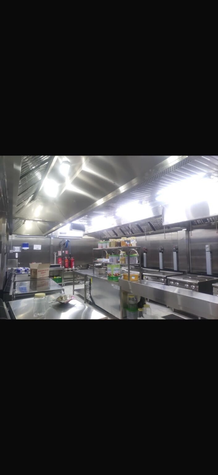 Hot kitchen with stainless-steel cooking ranges and extraction canopies