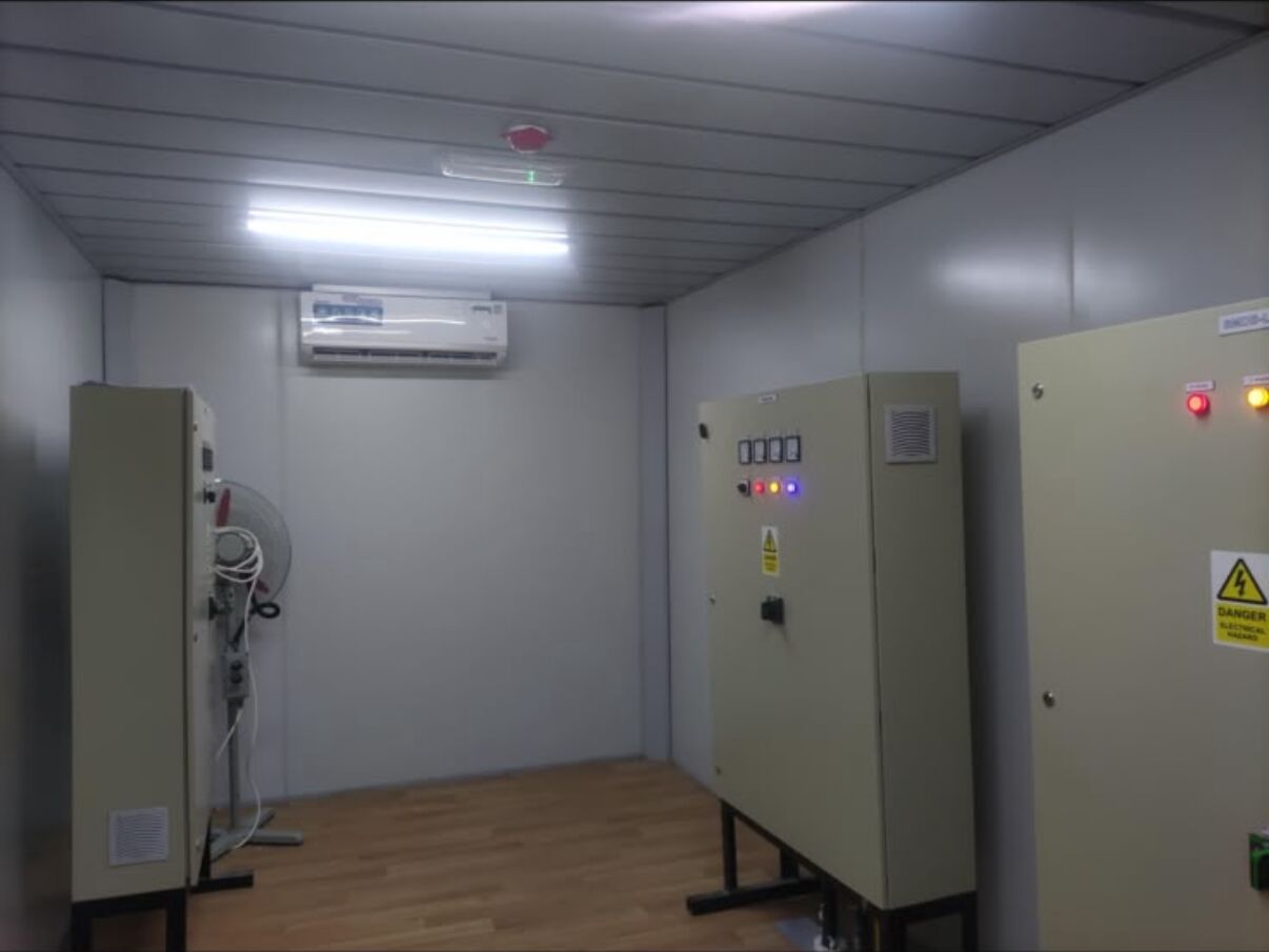 Electrical room with wall-mounted distribution panels inside a modular unit