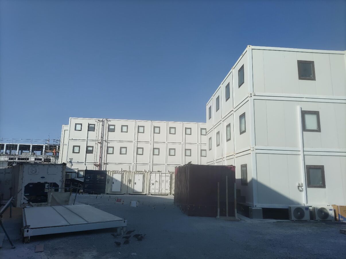 Modular buildings with storage containers arranged alongside them