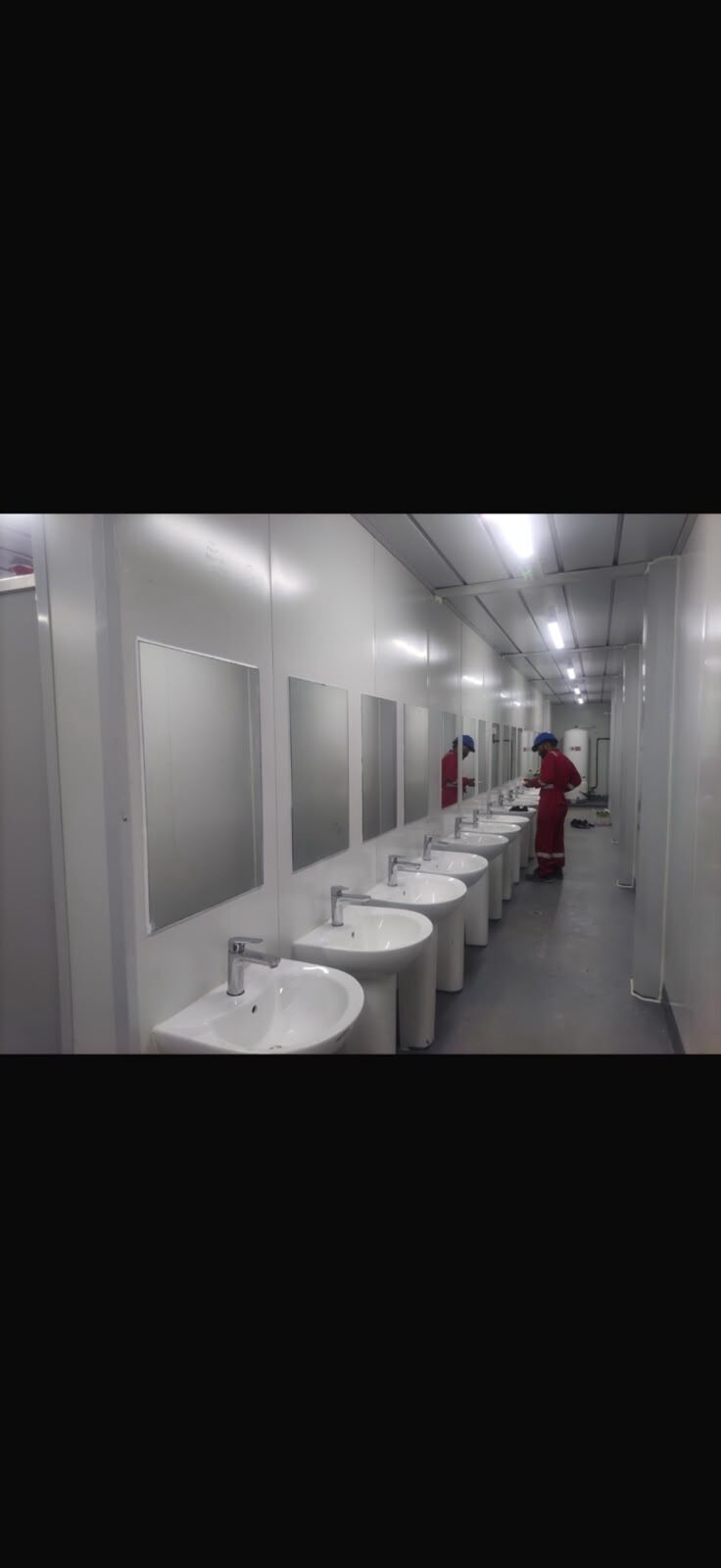 Shared shower cubicles and washbasin row in an accommodation building