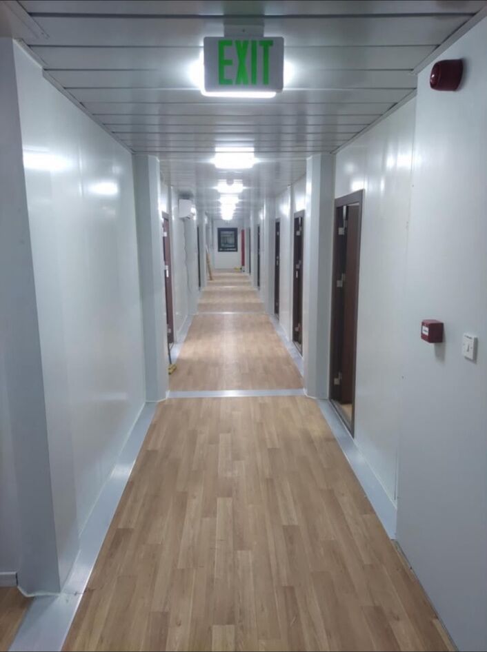 Accommodation corridor with illuminated exit signage overhead