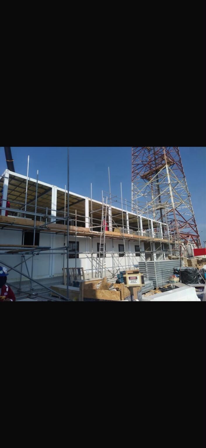 Modular units being installed and stacked on site with scaffolding in place