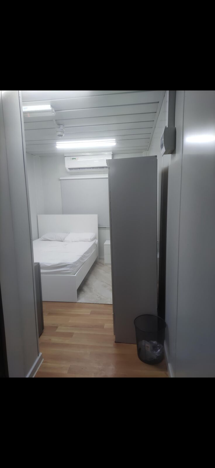 Senior accommodation room with single bed, wardrobe and vinyl wood flooring