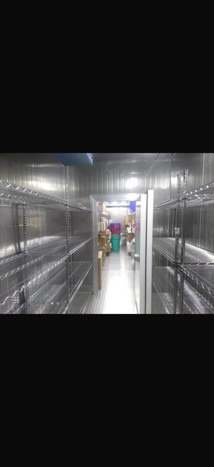 Dry storage room with shelving racks along both walls
