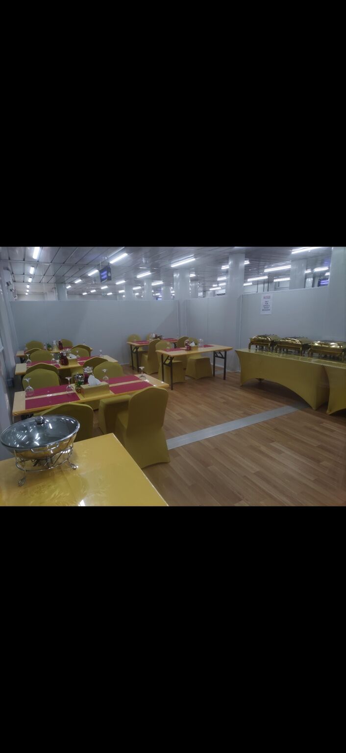 Senior mess hall with rows of dining tables under a lit ceiling